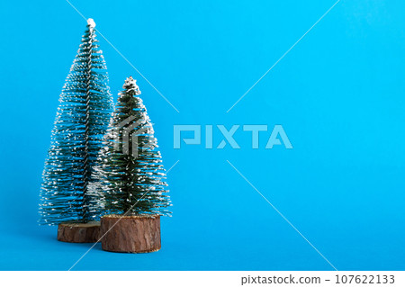 One small Christmas tree on colored background. new year decoration with copy space One small Christmas tree on colored background. new year decoration with copy space 107622133