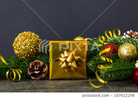 New Year Christmas mood, gift box, branches of a christmas tree, New Year decorations on a colored background New Year Christmas mood, gift box, branches of a christmas tree, New Year decorations on a colored background 107622206