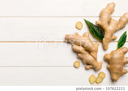 Finely dry Ginger powder in bowl with green leaves isolated on colored background. top view flat lay Finely dry Ginger powder in bowl with green leaves isolated on colored background. top view flat lay 107622211