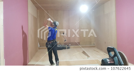 worker installing tiles on a floor worker installing tiles on a floor 107622645