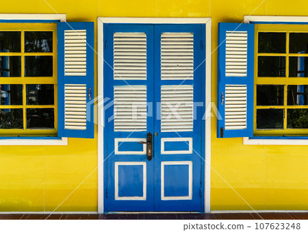 Closed wooden door and opened windows in positive colors 107623248