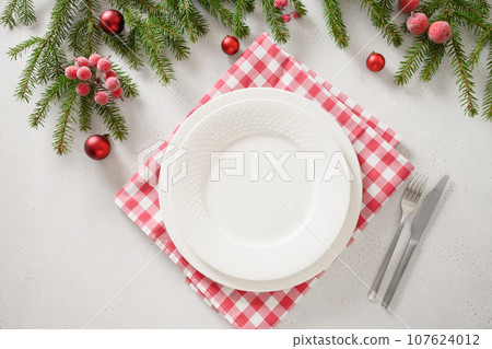 Christmas table setting with elegant red decorations on white background. Christmas table setting with elegant red decorations on white background. 107624012