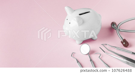 Piggy bank and dental tools on pink background, copy space 107626488