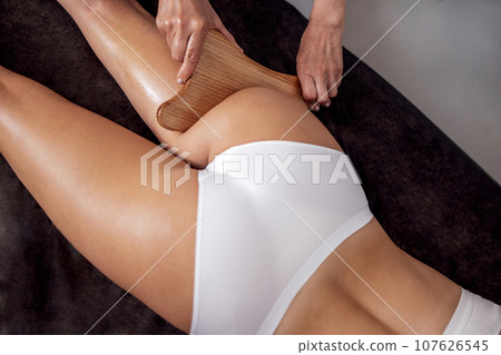Massage madera. Maderotherapy anti cellulite massage treatment with wooden prop Massage madera. Maderotherapy anti cellulite massage treatment with wooden prop 107626545