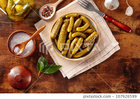 Pickled cucumbers with salt, pepper, garlic, and bay leaf 107626599