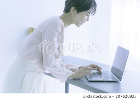一位微笑的年輕女子操作筆記型電腦的肖像 107626925