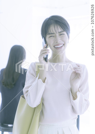 一位微笑的年輕女子在智慧型手機上交談的肖像,垂直位置 一位微笑的年輕女子在智慧型手機上交談的肖像,垂直位置 107626926