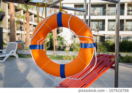 A circle for saving drowning people hangs near the pool 107628766