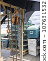 A seashore port town piled with fishery-related tools, chains, pulleys, and fishing nets 107631532