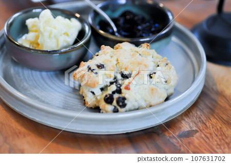 scone , blueberry scone or scone with whipped cream and blueberry dressing scone , blueberry scone or scone with whipped cream and blueberry dressing 107631702