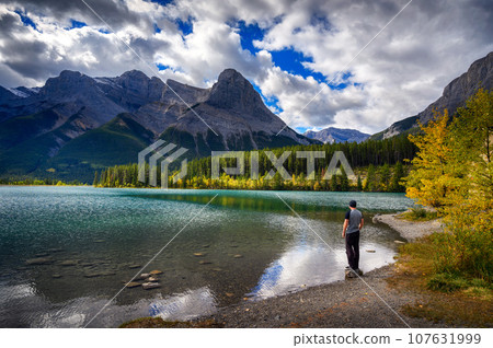 Hiker enjoys the view of Rundle Forebay Reservoir in Canmore, Canada 107631999