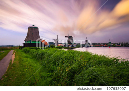 Sunset above farm houses and windmills of Zaanse Schans in the Netherlands 107632007