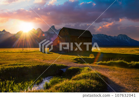 Sunset over a historic barn at Mormon Row in Grand Teton National Park, Wyoming 107632041
