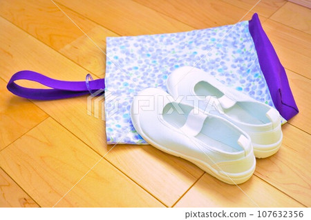 Purple handmade mimosa flower pattern shoe holder and new slippers on the flooring Purple handmade mimosa flower pattern shoe holder and new slippers on the flooring 107632356