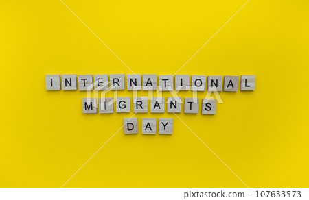 December 18, International Migrants Day, minimalistic banner with the inscription in wooden letters on an orange background December 18, International Migrants Day, minimalistic banner with the inscription in wooden letters on an orange background 107633573