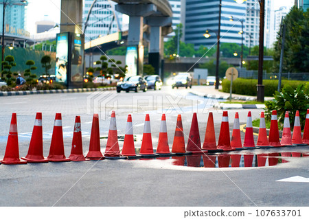 A number of red traffic cones, limiting the passage A number of red traffic cones, limiting the passage 107633701