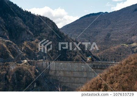 The dam of the Inguri hydroelectric power plant in the Sakartvelo mountains. A natural mountain landscape with energetic infrastructure 107633729