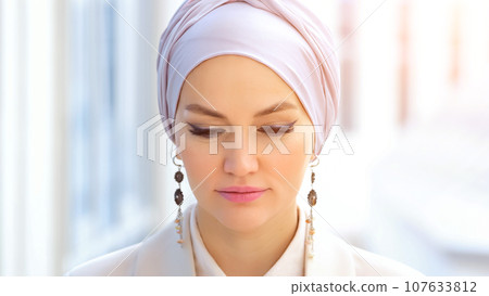 Muslim businesswoman in silver hijab looks smilingly Muslim businesswoman in silver hijab looks smilingly 107633812