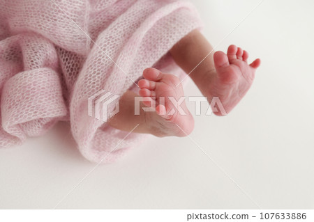 Close-up of tiny, cute, bare toes, heels and feet of a newborn girl, boy. Baby foot on pink soft coverlet, blanket. Detail of a newborn baby legs. Macro horizontal professional studio photo. Close-up of tiny, cute, bare toes, heels and feet of a newborn girl, boy. Baby foot on pink soft coverlet, blanket. Detail of a newborn baby legs. Macro horizontal professional studio photo. 107633886