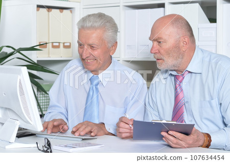 two old elderly businessmen working in office two old elderly businessmen working in office 107634454