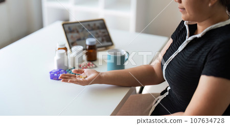 Women organize check the medicine bottle her medication into pill dispenser. female taking pills from box. Healthcare and concept with medicines. medicaments on table 107634728