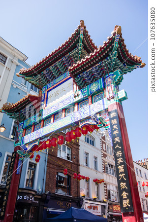 The ornate and heavily decorated gates of London's Chinatown under a deep blue sky The ornate and heavily decorated gates of London's Chinatown under a deep blue sky 107635080
