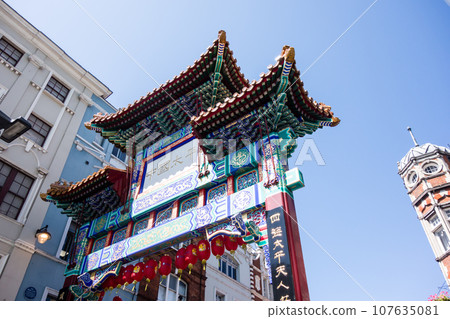 The ornate and heavily decorated gates of London's Chinatown under a deep blue sky 107635081