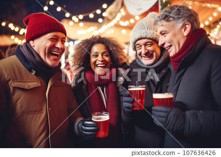 Multiracial friends of different ages drinking mulled wine at Christmas fair in festively decorated city Multiracial friends of different ages drinking mulled wine at Christmas fair in festively decorated city 107636426
