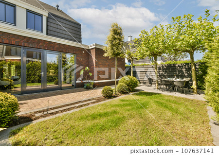 an outside area with grass, bushes, and trees in front of a house that has been built for sale 107637141