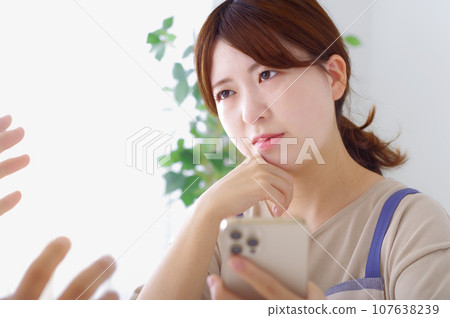 女人看著男人的智慧型手機時表情複雜 107638239