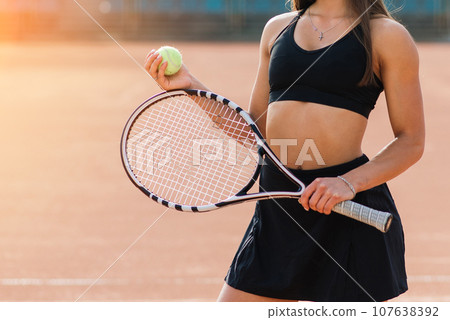 Beautiful stylish sexy woman in black trendy sportswear on tennis court. 107638392