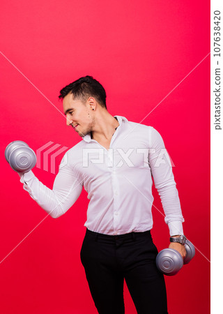 Business man with fitness dumbbells wear shirt. Studio shooting on red background Business man with fitness dumbbells wear shirt. Studio shooting on red background 107638420