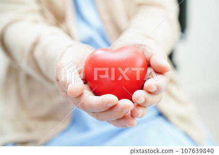 Bangkok, Thailand April 1, 2023 Asian elderly woman patient holding globe in hand at hospital. 107639840