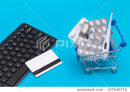 Ordering Medicines. Pills and Capsules in a Shopping Cart on Blue Background 107640758