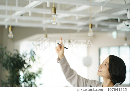 一名穿著工作服的婦女正在進行建築維護 一名穿著工作服的婦女正在進行建築維護 107641215