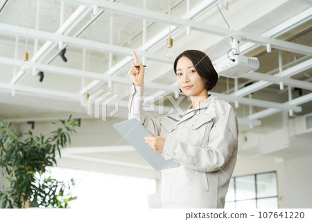 一名穿著工作服的婦女正在進行建築維護 一名穿著工作服的婦女正在進行建築維護 107641220