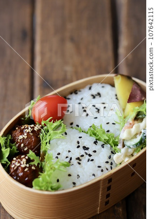 A bento lunch of sesame and salt rice balls in a bento box 107642115