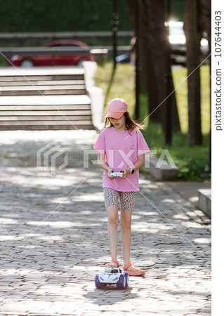 Girl playing with remote control car 107644403