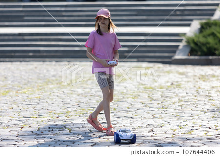 Girl playing with remote control car 107644406
