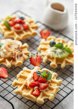Freshly baked waffles with strawberries and blueberries 107644449