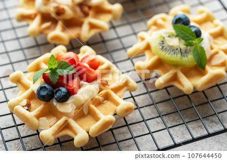 Freshly baked waffles with strawberries and blueberries 107644450