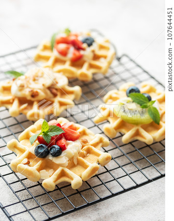 Freshly baked waffles with strawberries and blueberries 107644451