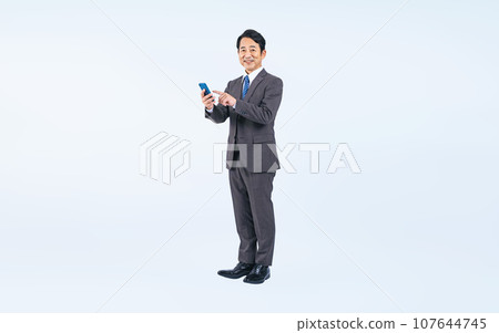 Middle-aged businessman using a smartphone (Cutout PNGs are also on sale! See author profile) 107644745