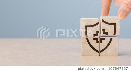 Hand arranging wood block stacking with icon shield and medical cross. healthcare medical. Insurance and medical health concept. copy space 107647567