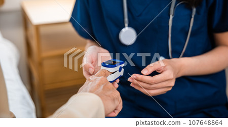 Asian nurse home service checking with fingertip pulse oximeter oxygen saturation meter blood monitor finger on finger of senior old man, Young woman putting oximeter of finger aged adult patient Asian nurse home service checking with fingertip pulse oximeter oxygen saturation meter blood monitor finger on finger of senior old man, Young woman putting oximeter of finger aged adult patient 107648864