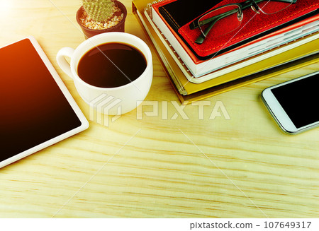 Smart phone,coffee cup,and stack of book on wooden table 107649317