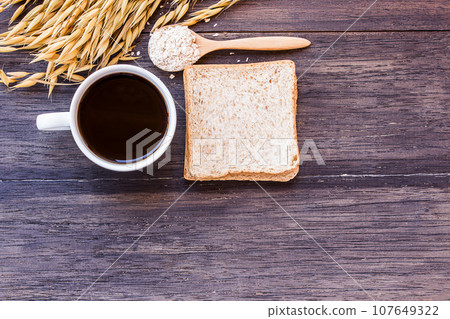 Ears of wheat and coffee with slice of bread on dark wooden 107649322