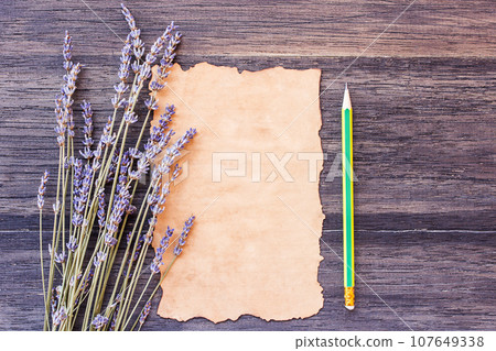 Lavender flower and old paper with pencil on the old wooden table 107649338