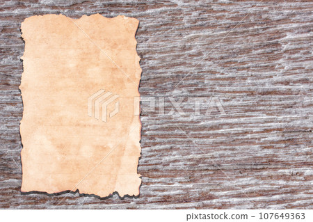 Old paper on brown aged wood 107649363