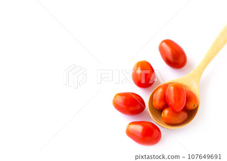 Red tometos in wooden spoon on white background 107649691
